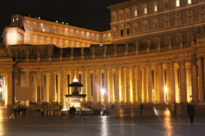 Night view of St. Peter's Square: one of the fountains and the columns surrounding the square