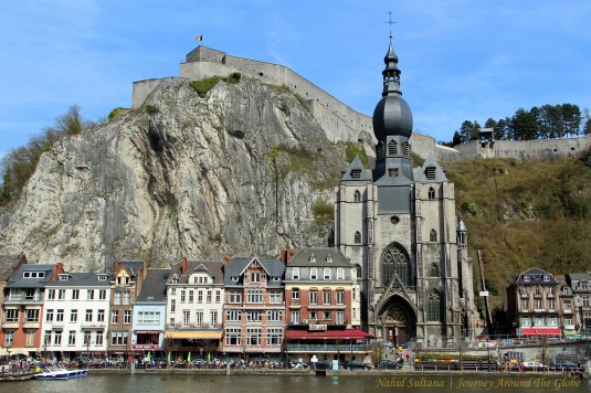 Collegiate Cathedral of Dinant and the citadel in the backdrop with River Meuse flowing in the front in Dinant, Belgium
