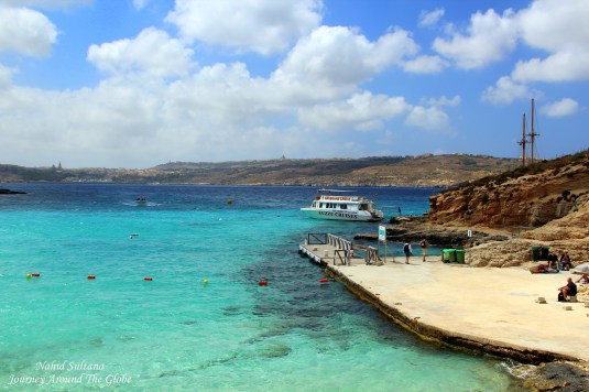 Our boat "Luzzu Cruise" standing on the azure water of Blue Lagoon in Comino, Malta