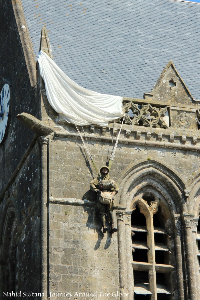 A dummy dangling from St. Mere Eglise commemorating paratrooper John Steele whose parachute got caught in this church's spire on June 6, 1944, Normandy, France