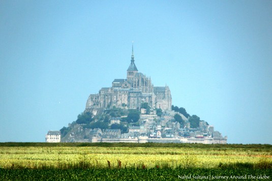 Pyramidal shape of Mont St. Michel from afar in Normandy, France