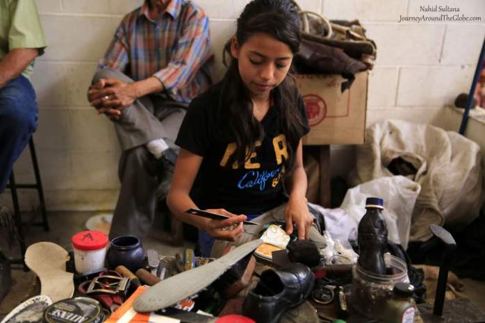 A little girl fixing shoes inside Marcado Municipal de Suchitoto, El Salvador